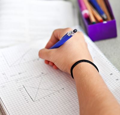 Bild på en hand med penna som skriver på ett papper