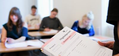 Bild på människor som sitter bid skrivbord och skriver